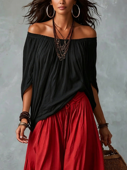 Top noir épaules dénudées et pantalon rouge ample coupe ballon