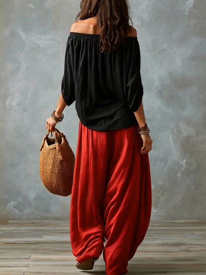 Top noir épaules dénudées et pantalon rouge ample coupe ballon